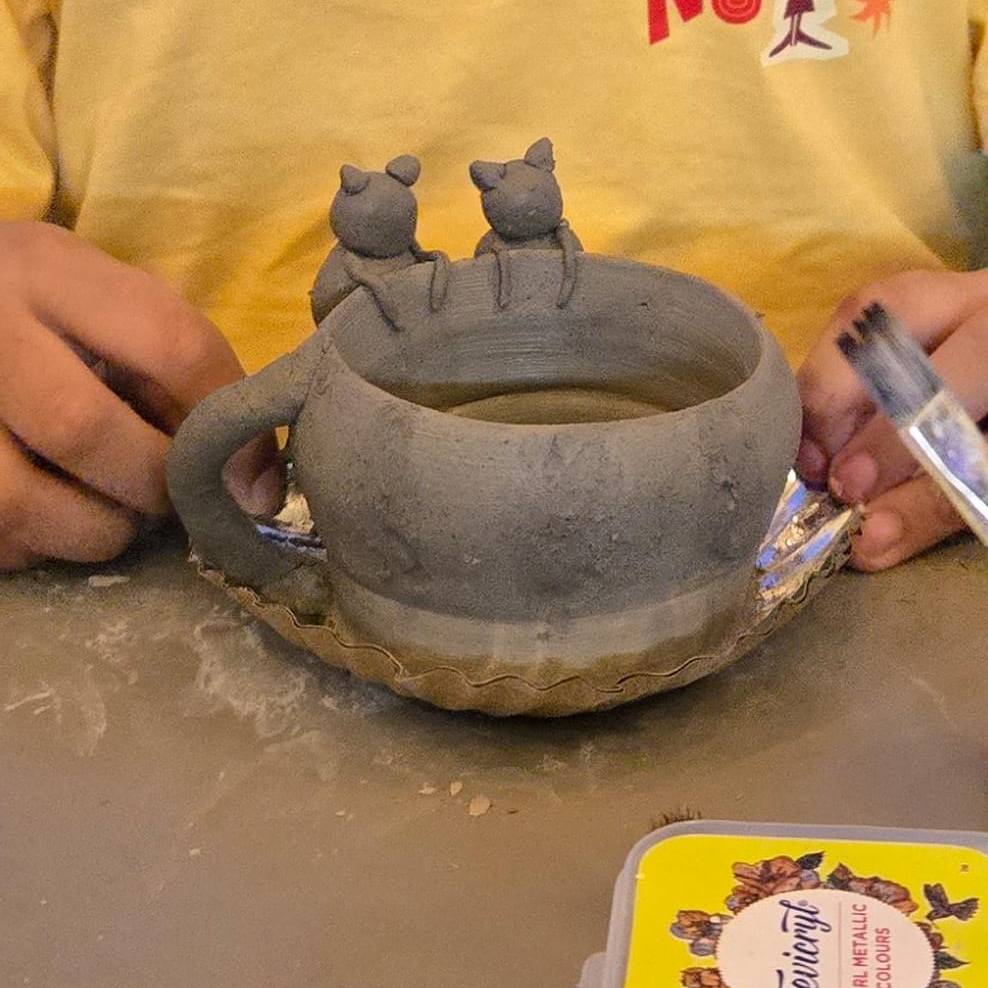Pottery sculpting process close-up highlighting tool marks.