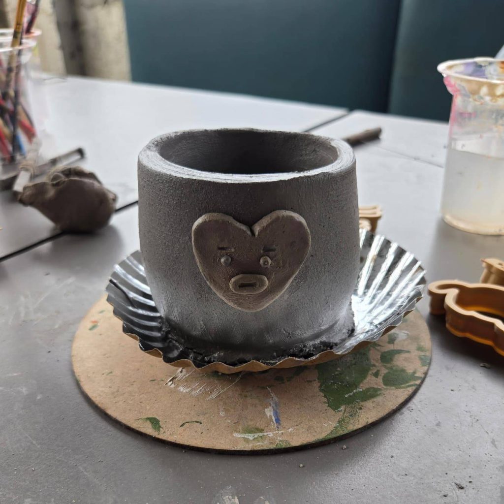 Hand-carved ceramic vase featuring unique surface textures.