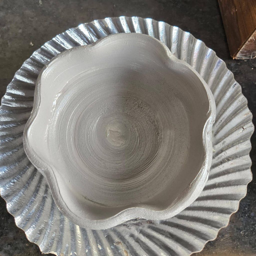 Pottery sculpting tools in use during clay modeling.
