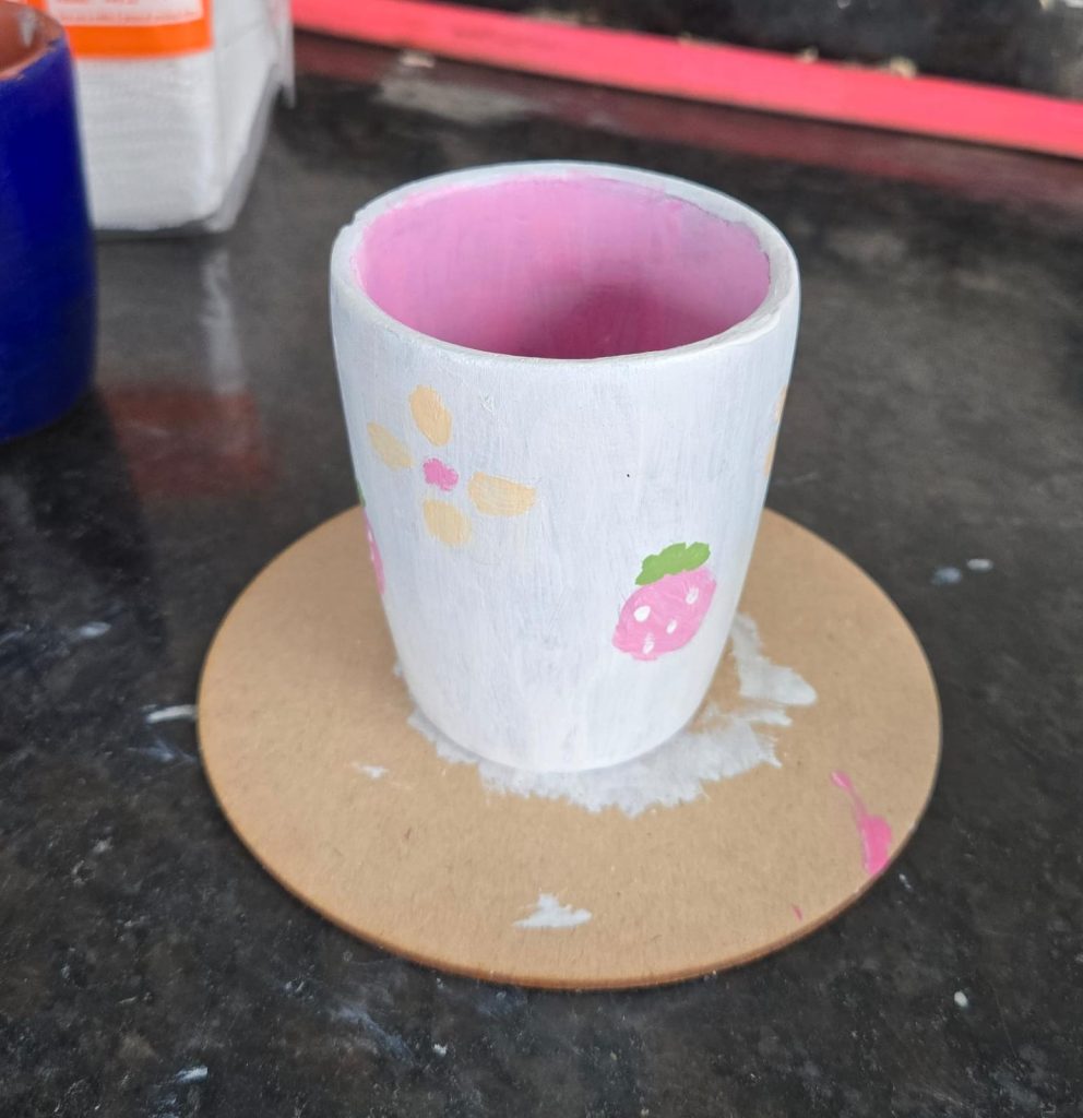 Set of painted ceramic teacups with pastel floral designs.