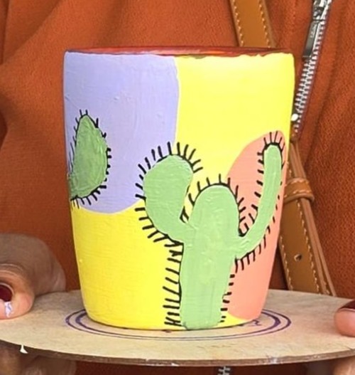 Closeup of a pastel-painted pottery piece showcasing brushwork.
